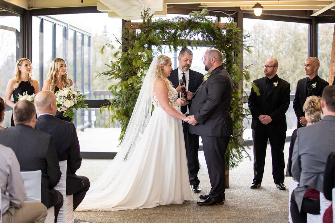 Indoor ceremony under a greenery arch