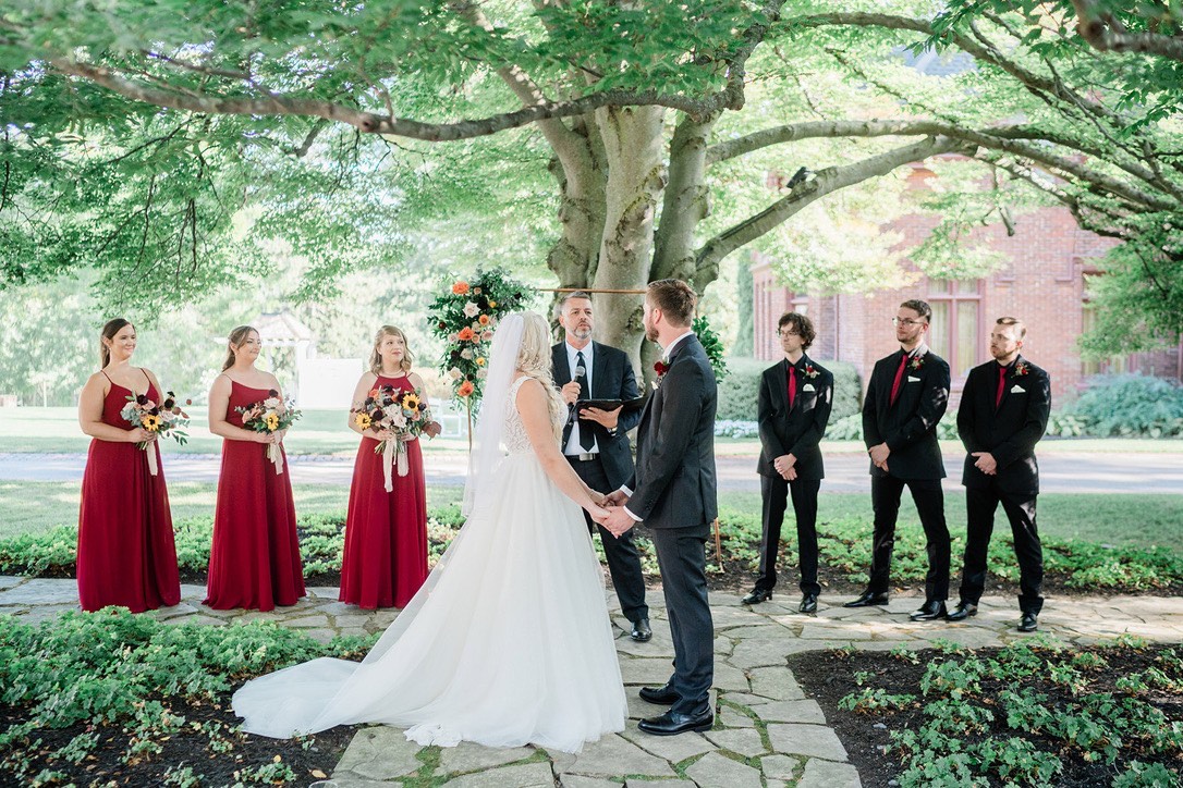 Phil officiating beneath a tree with the wedding party looking on